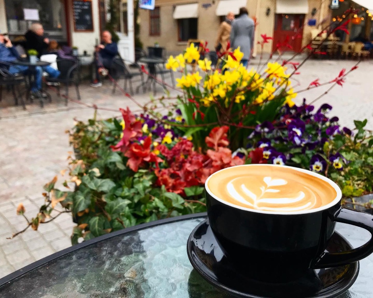 Caffè latte på ett bord med vårblommor