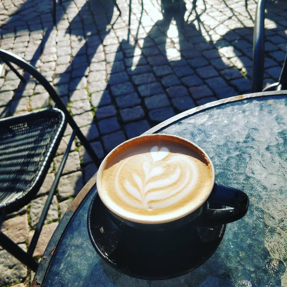 Caffè latte på ett bord i solen